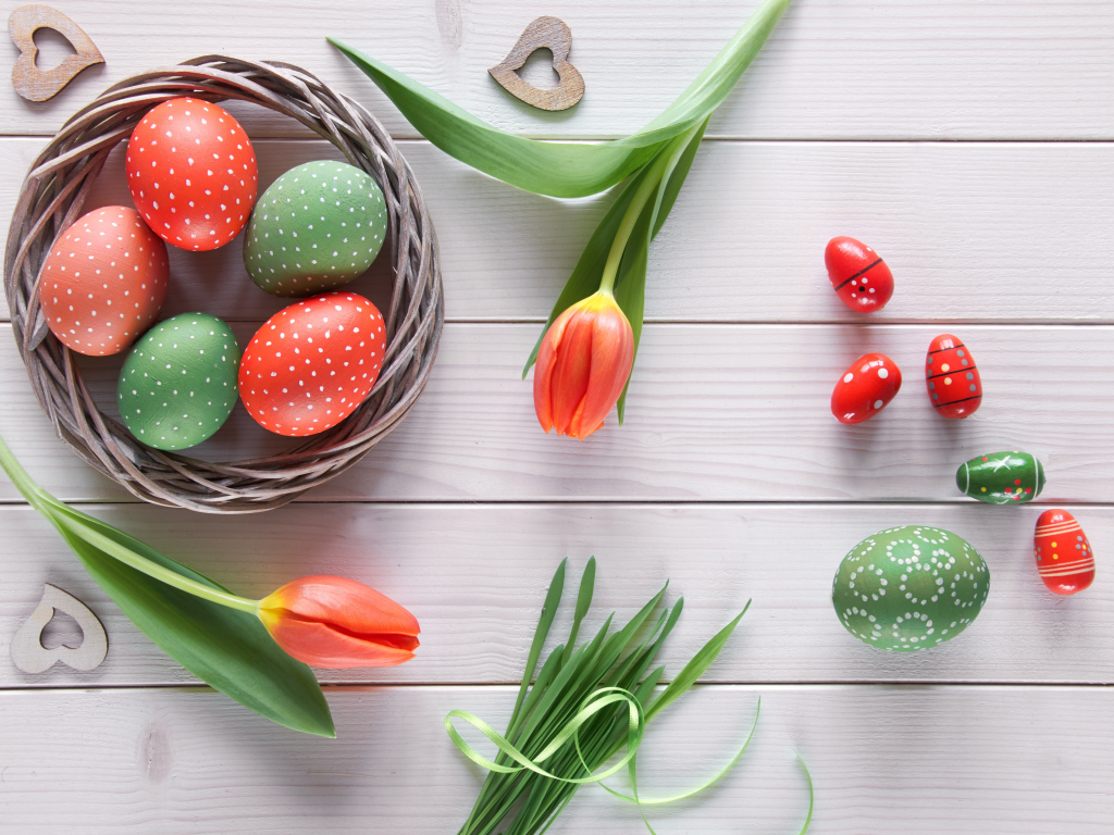 Красивые яйца с тюльпанами на белом столе на Пасху