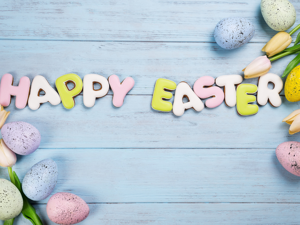 Печенье с надписью счастливой Пасхи с яйцами и цветами