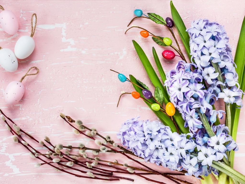 Цветы гиацинта с ветками вербы и яйцами на розовом фоне
