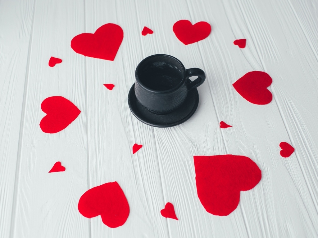 Чашка кофе с красными сердечками на столе