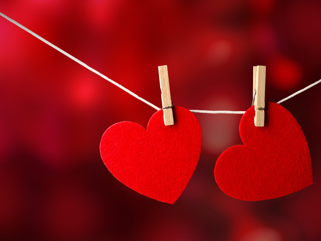 Два красных сердца висят на веревке