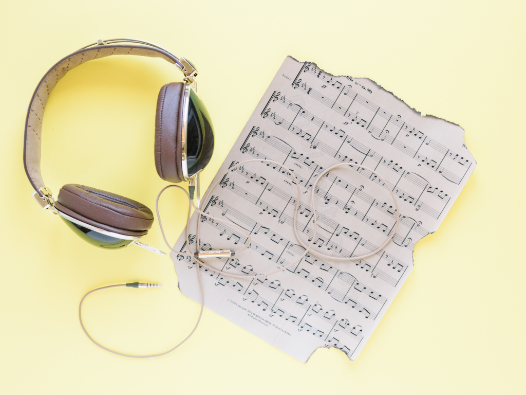 Старые ноты и наушники на желтом фоне