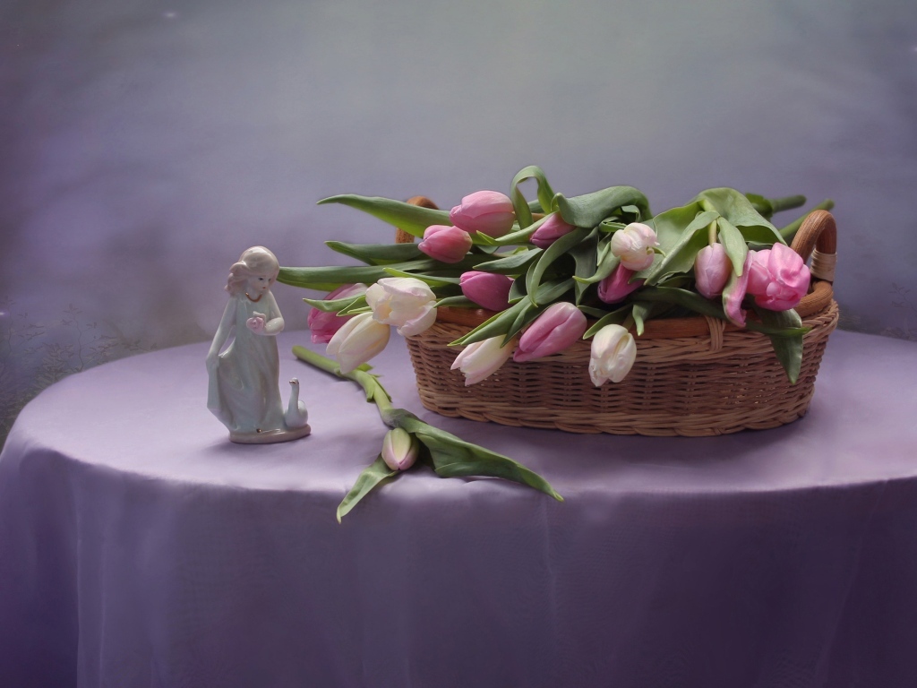 Корзина тюльпанов на столе со статуэткой