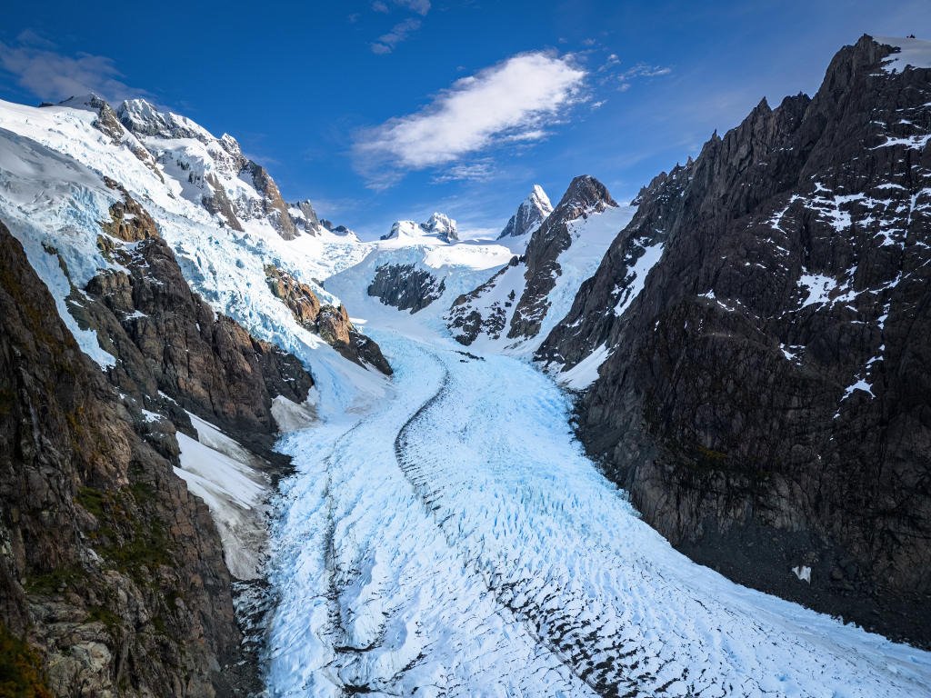 Заснеженная заледеневшая дорога между гор