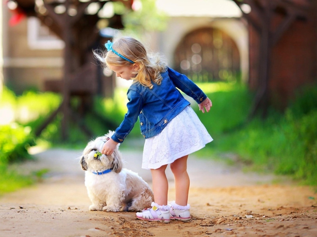 Маленькая девочка гуляет с собакой на улице 