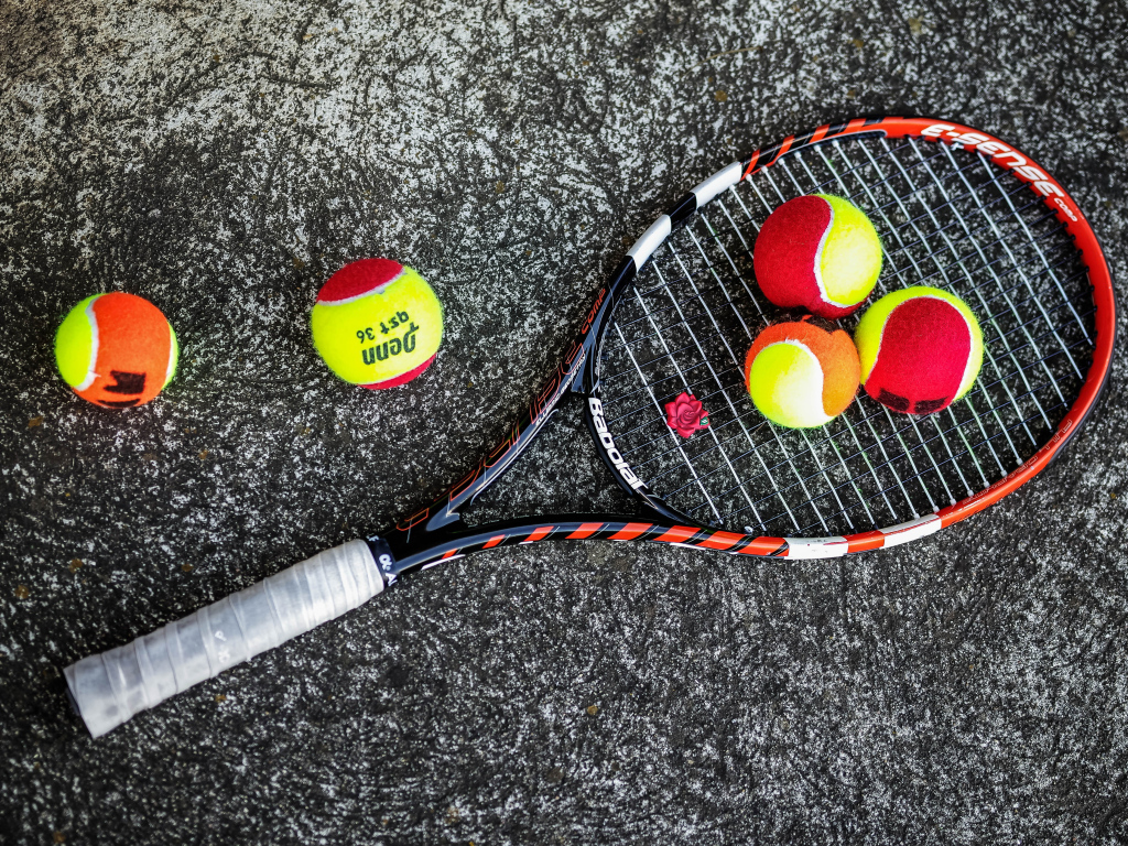 Ракетка и теннисные мячи на черном фоне