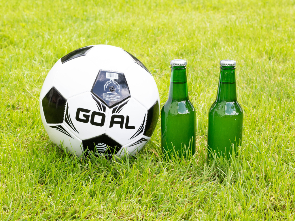Футбольный мяч и две бутылки пива на поле