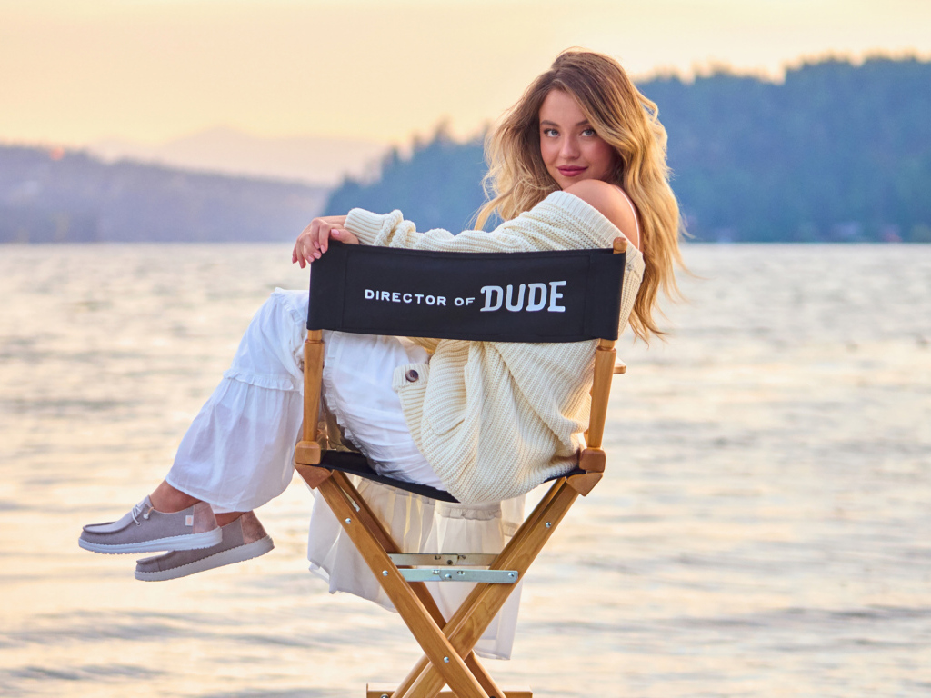 Актриса Сидни Суини сидит на стуле у озера