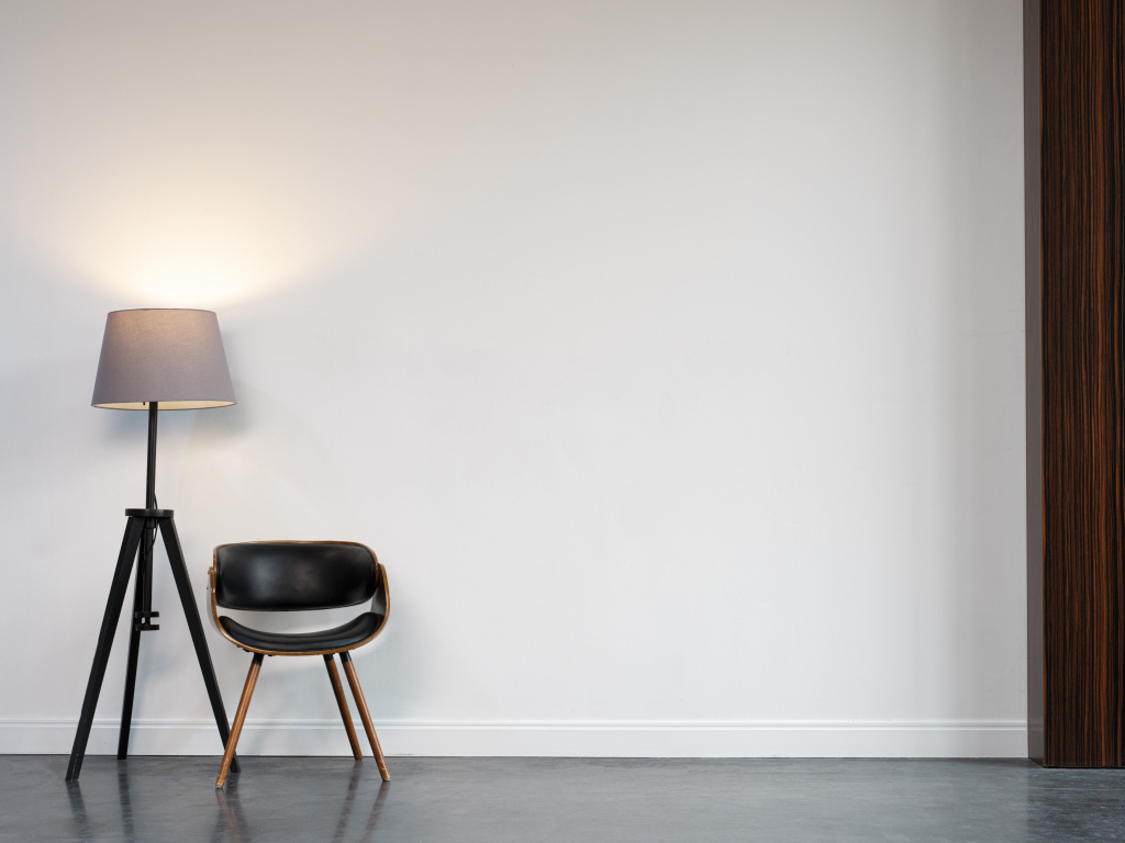 Кожаное кресло с торшером в пустой комнате