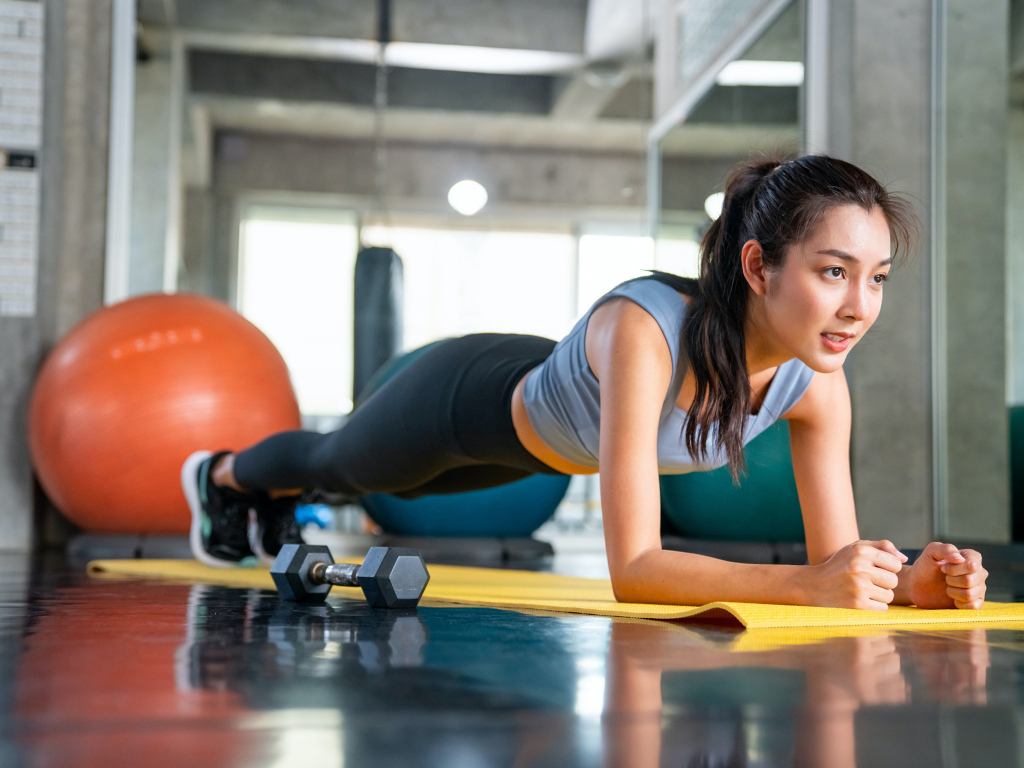 Спортивная девушка делает планку в спортзале