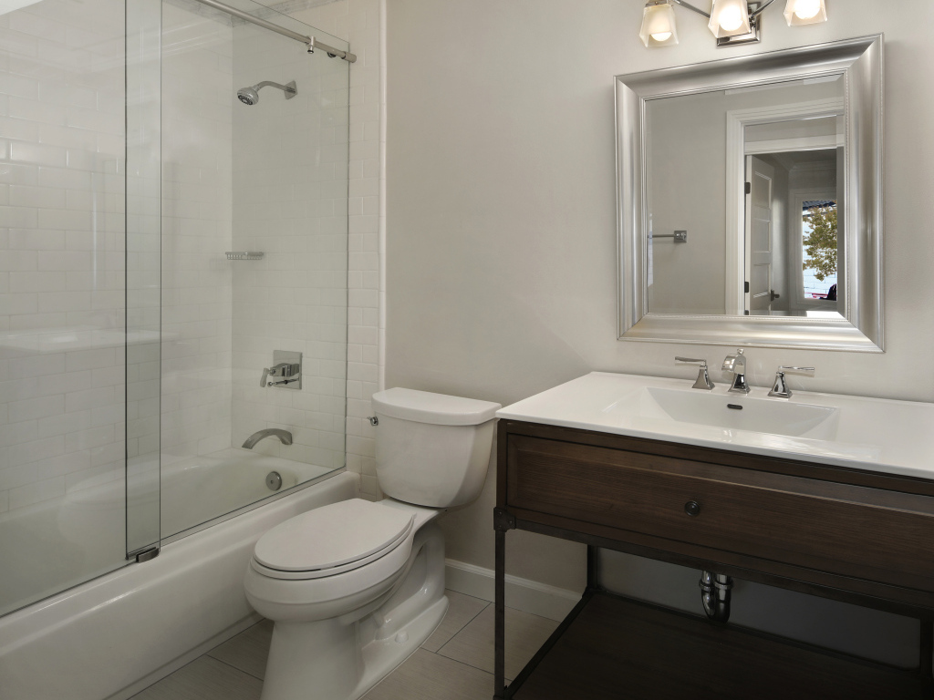 Интерьер ванной комнаты в белом цвете с душевой кабиной и унитазом