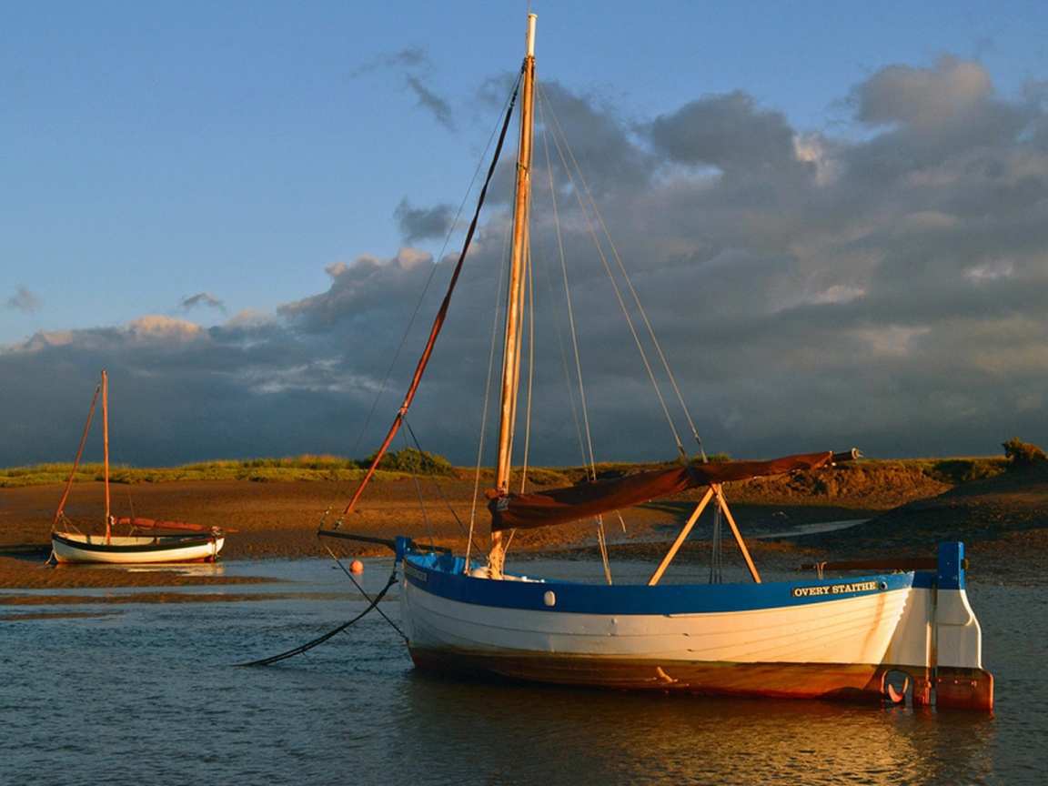 Парусная лодка стоит у берега