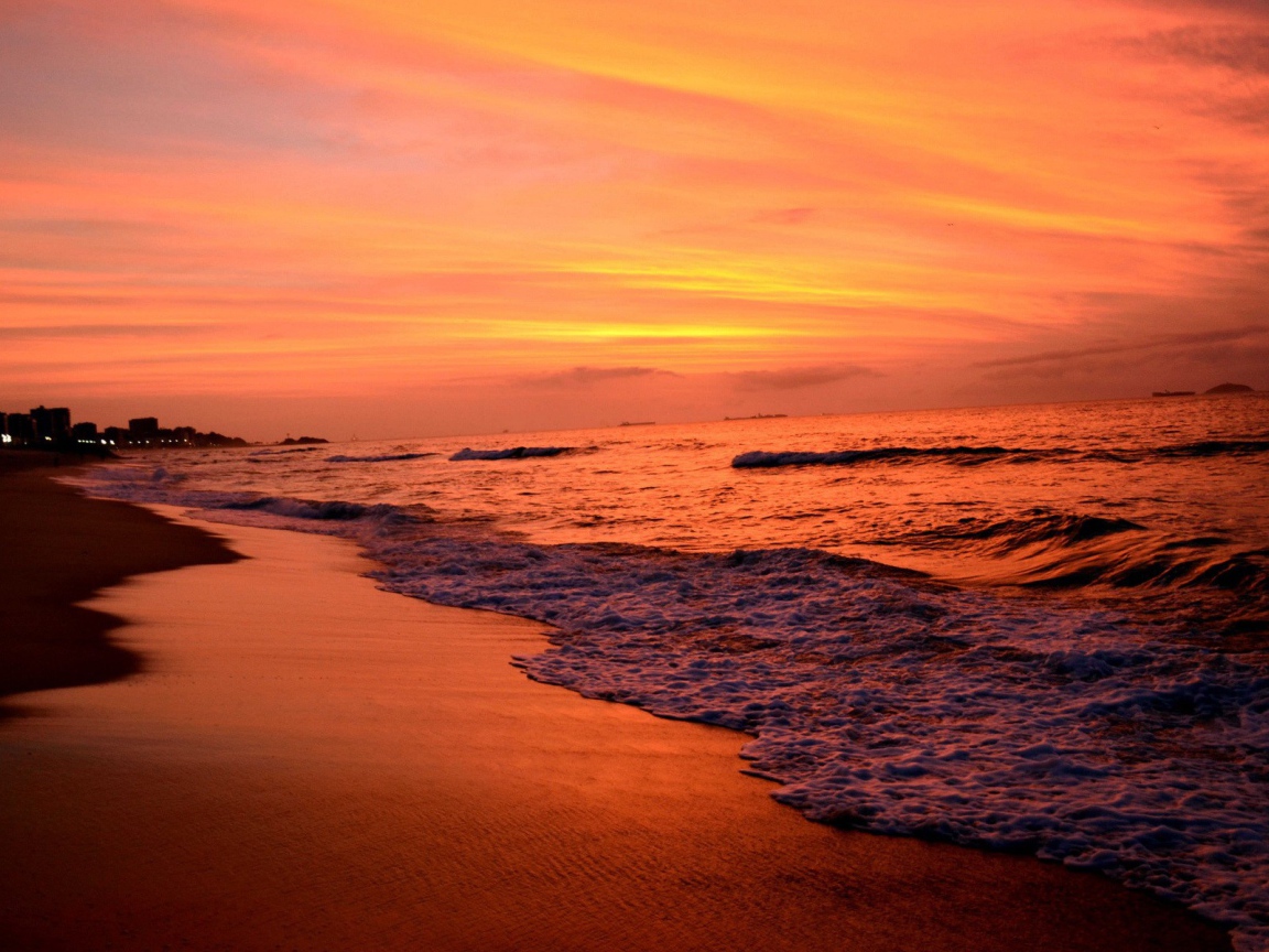 На закате волны лижут пляж