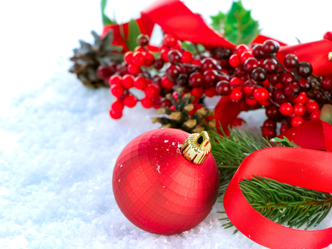 Красные ёлочные украшения на снегу