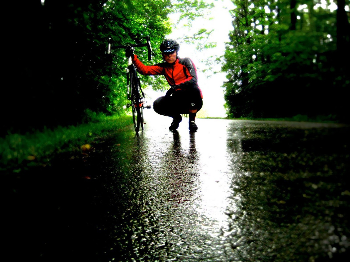 Велосипедист на мокрой дороге