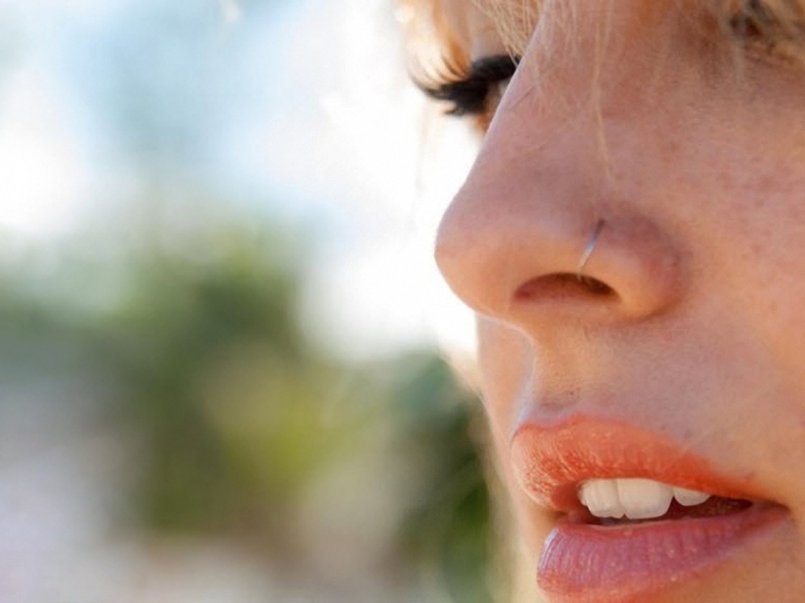 Девушка блондинка с пирсингом в носу крупным планом