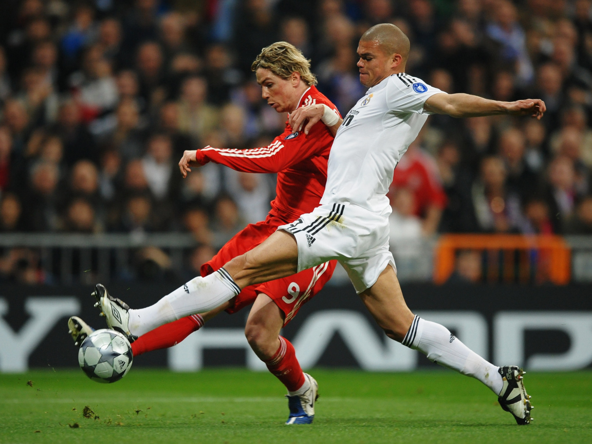 Игрок из Реал Мадрид Пепе пытается взять мяч