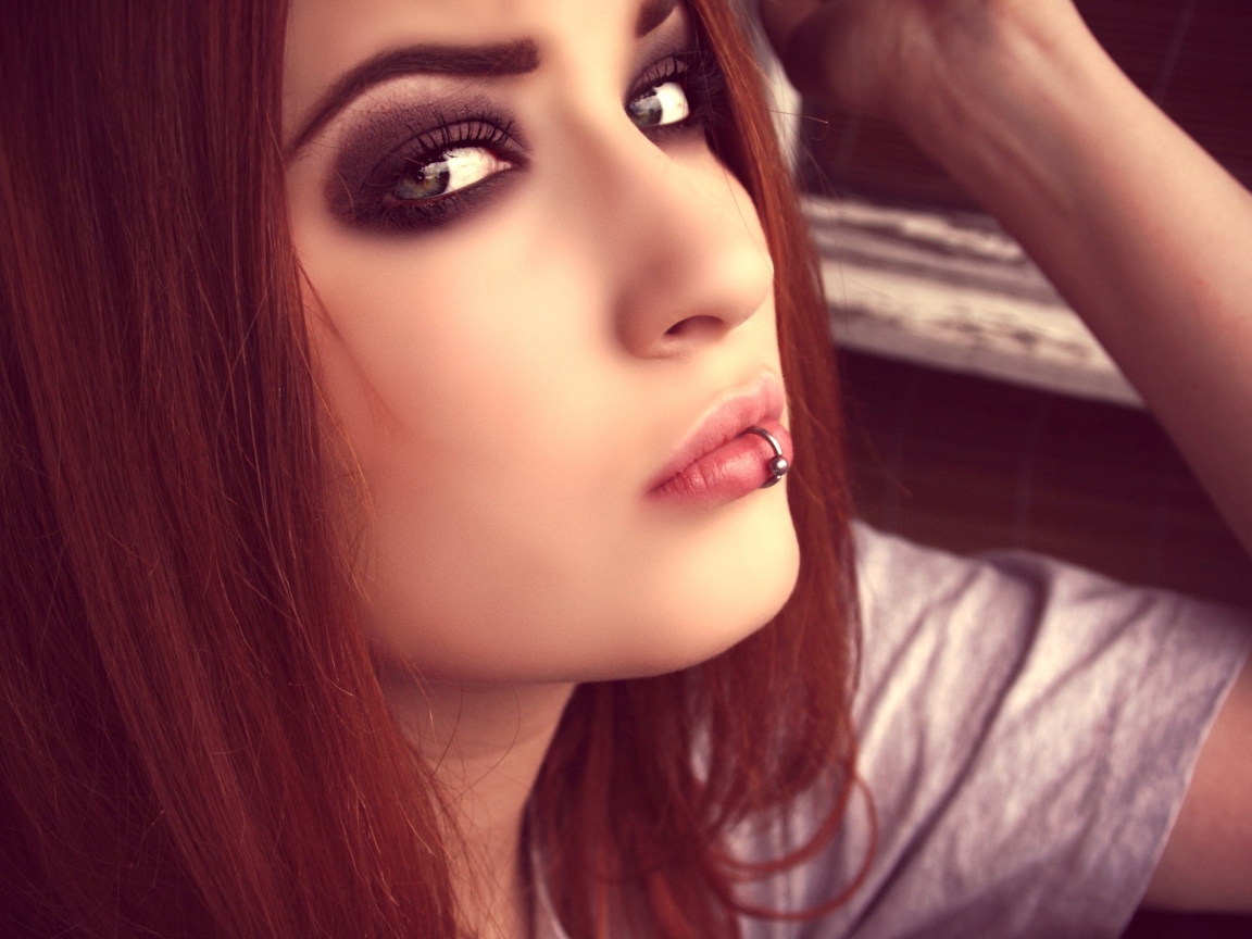 Молодая девушка шатенка с пирсингом в губе