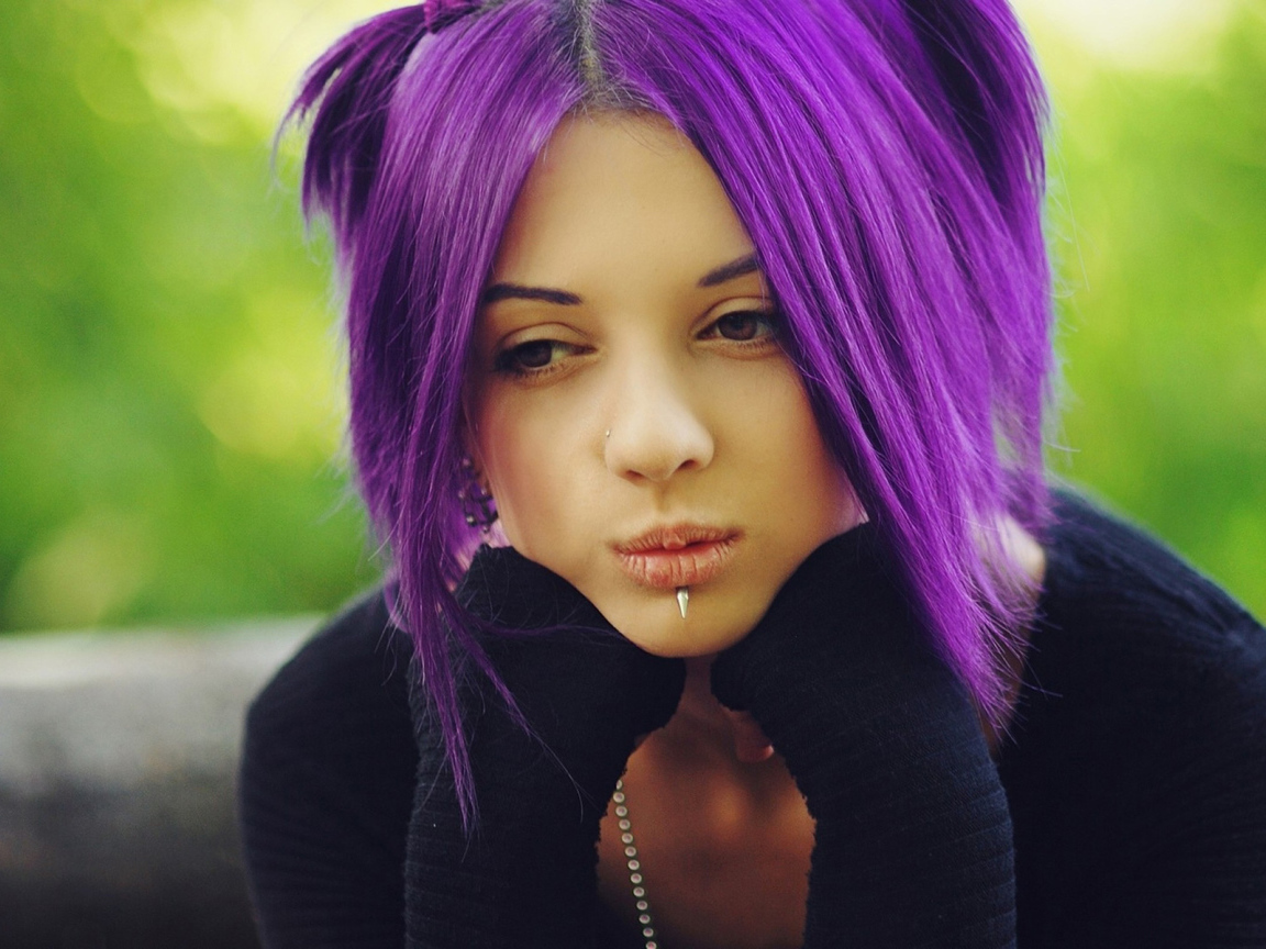 Молодая девушка с пирсингом в носу и губах