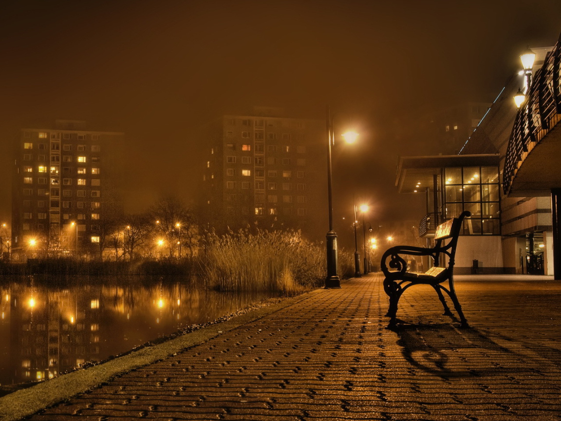 Скамейка около реки в городе