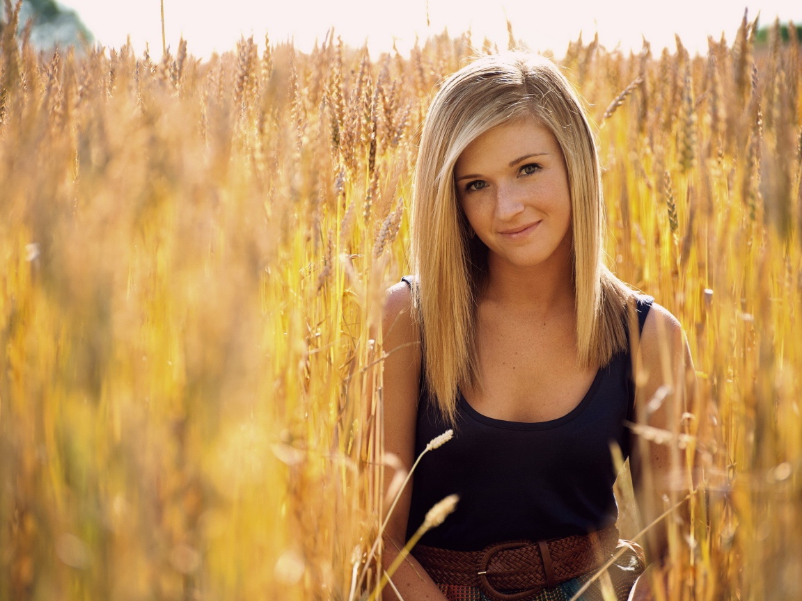 Девушка с веснушками среди пшеницы