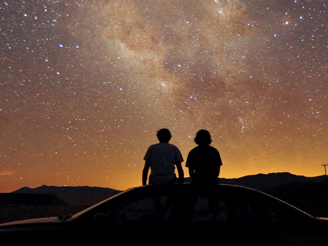 Милая пара на крыше автомобиля