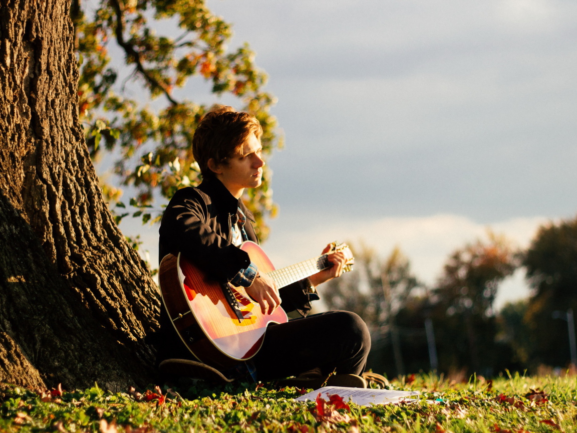 Парень с гитарой у дерева