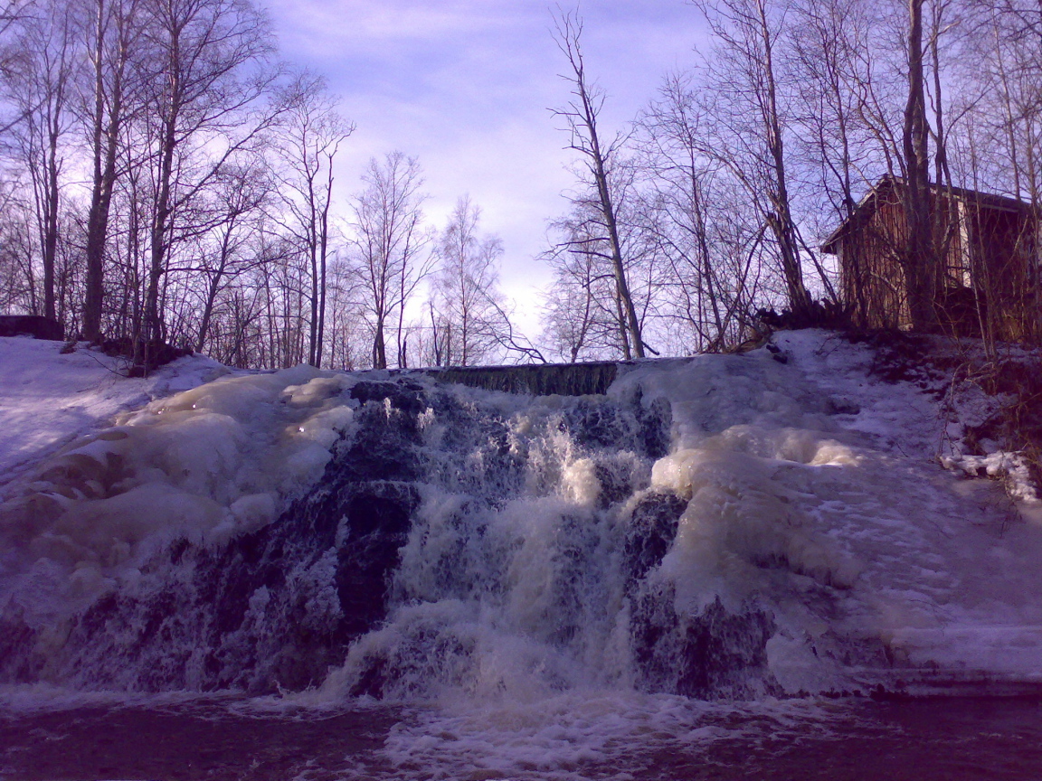 Замерзший водопад и хижина лесника