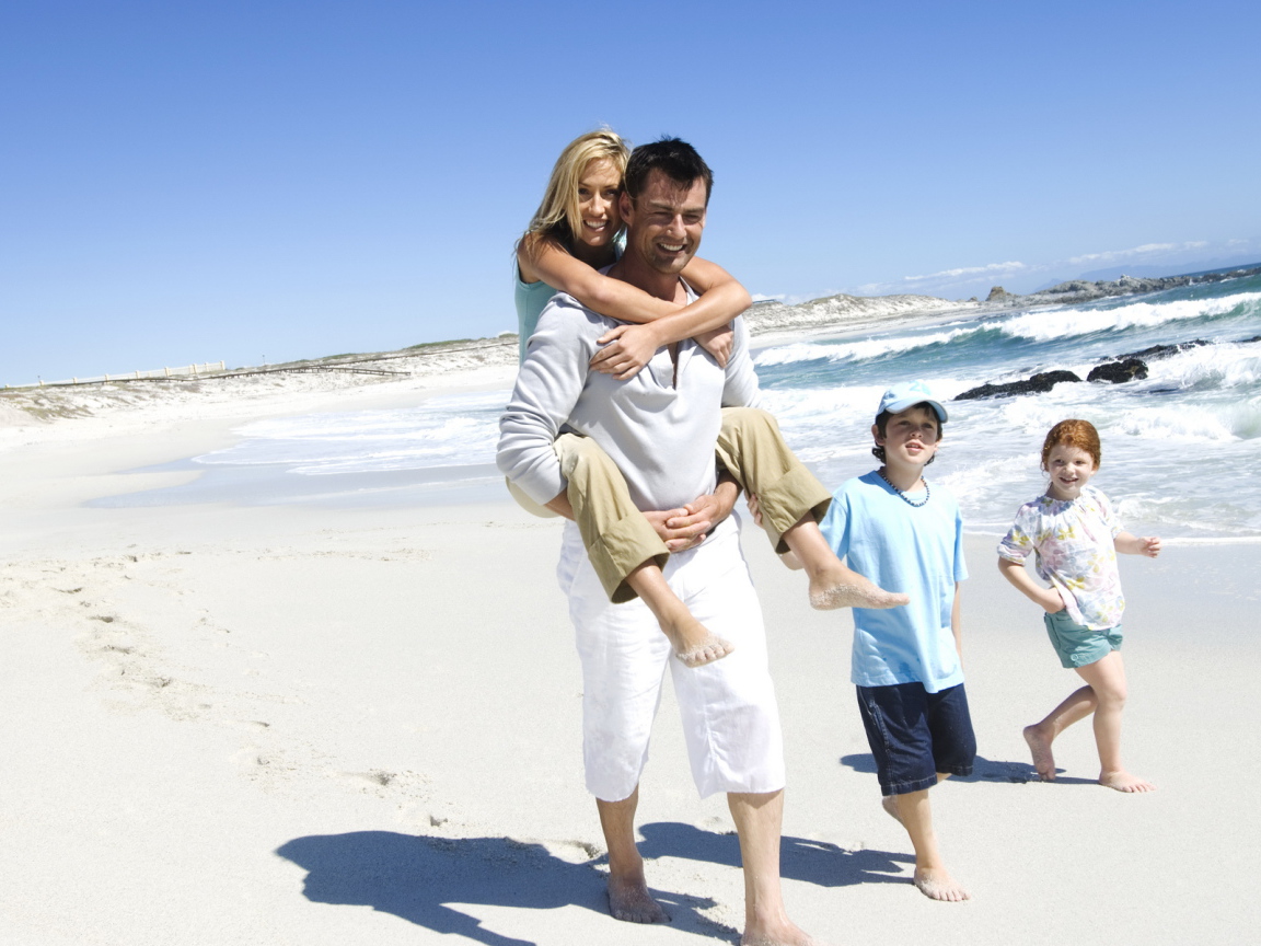 Семья гуляет по берегу