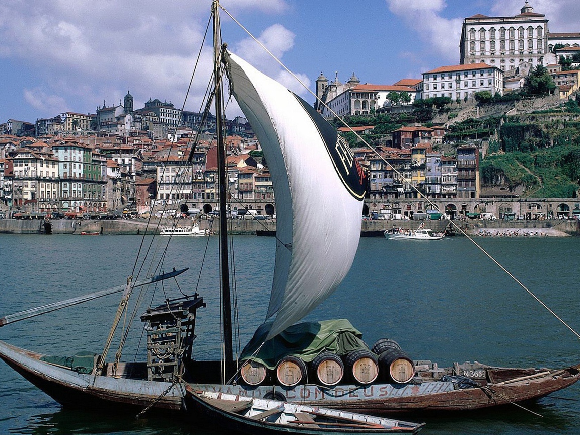 Парусная лодка на фоне города