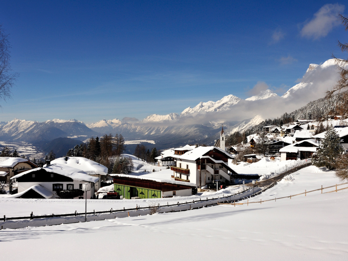 Дома на фоне гор на курорте Зеефельд, Австрия