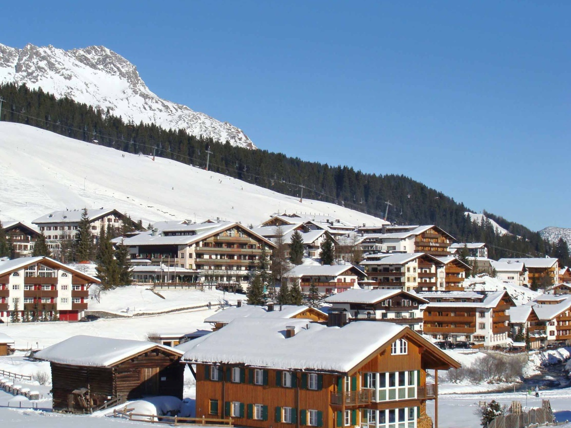 Дома на фоне гор на горнолыжном курорте Лех, Австрия