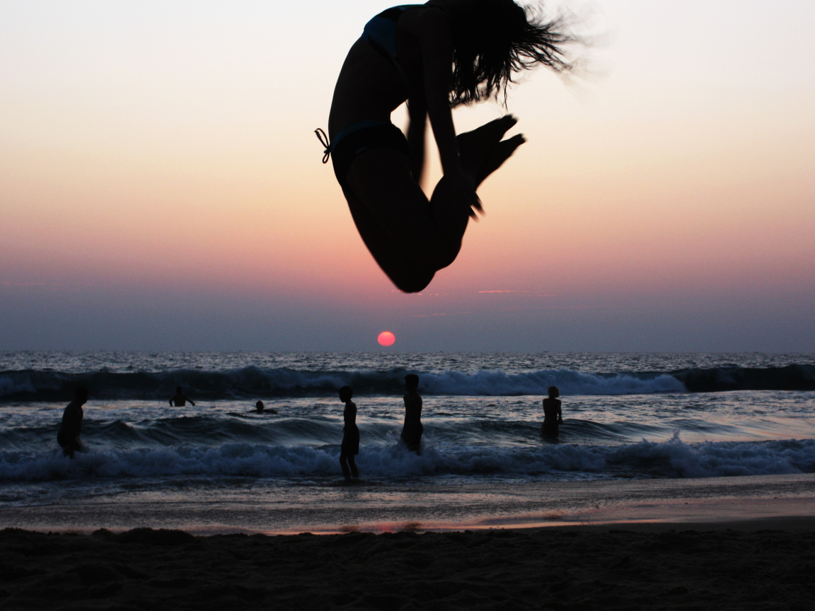 Девушка в прыжке на пляже в Варкале