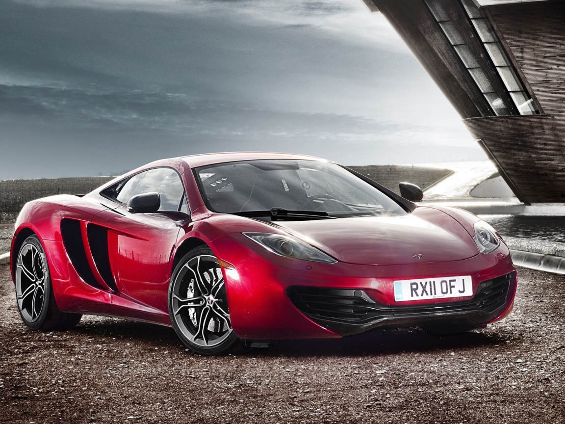 Красный McLaren на коричневом гравии