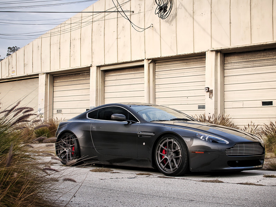 Автомобиль Aston Martin у складского здания