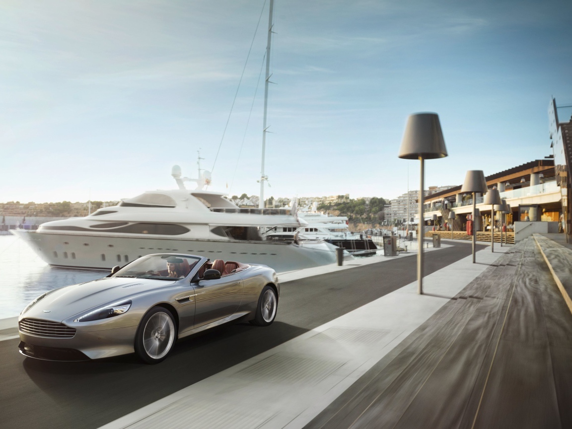 Convertible Aston Martin on the background of yachts
