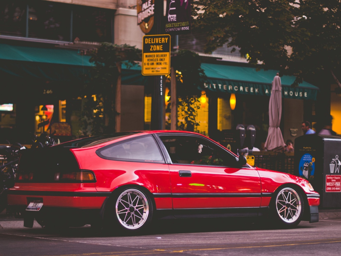 Красная Honda CRX стоит у уличного кафе