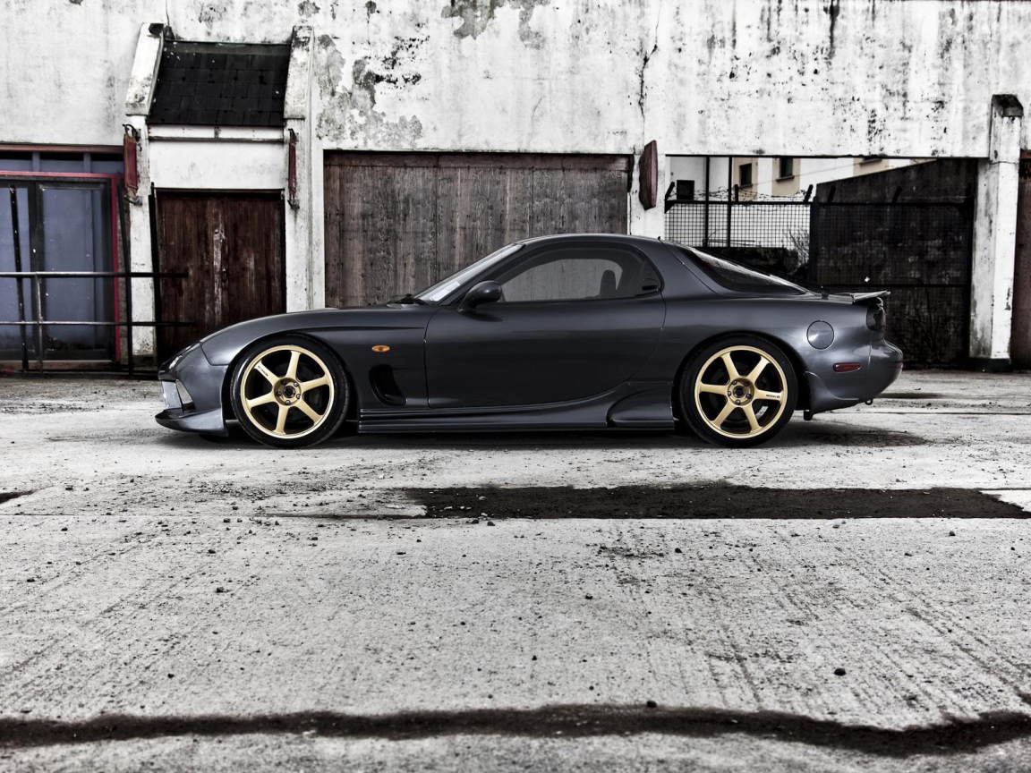 Черная Mazda RX-7 на сером бетоне