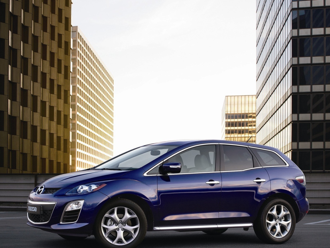 Семейный автомобиль Мазда на фоне городских зданий