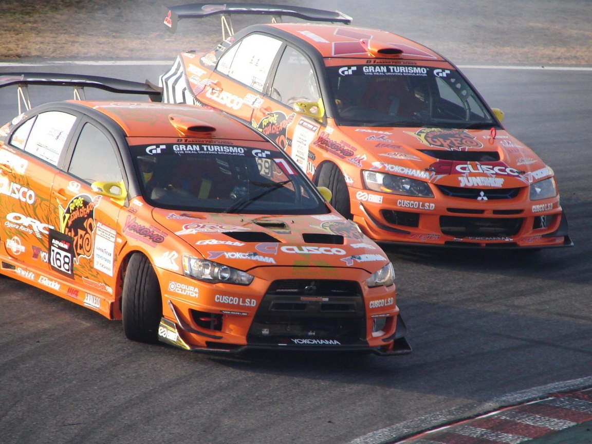 Два гоночных спортивных Mitsubishi Lancer Evolution IX