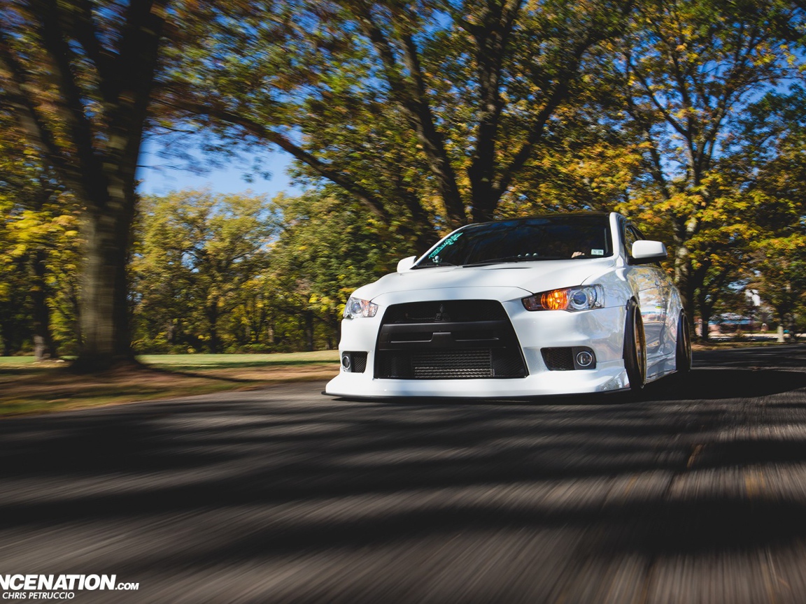 Белый Mitsubishi Lancer Evo X на дороге
