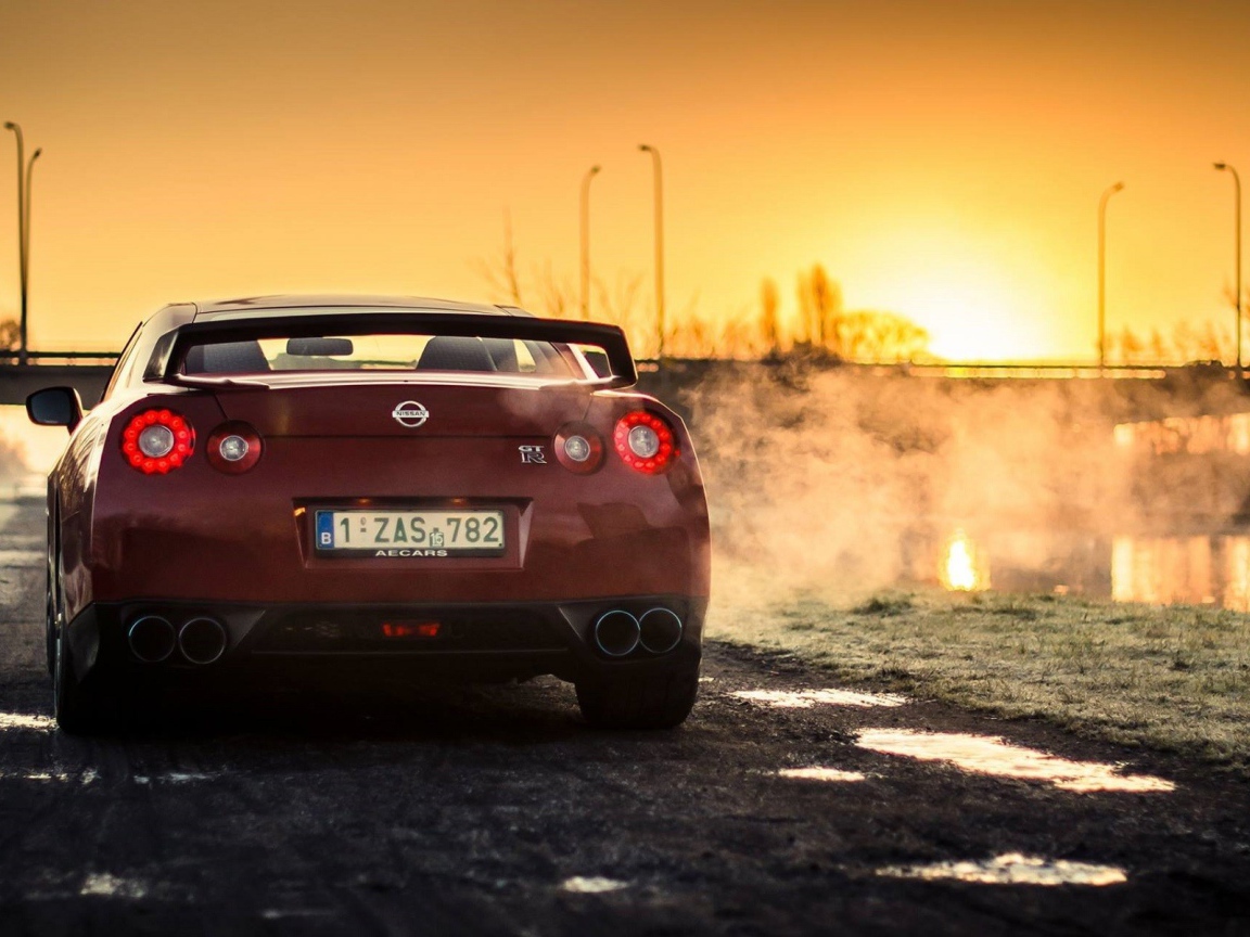 Красный Nissan у реки на рассвете