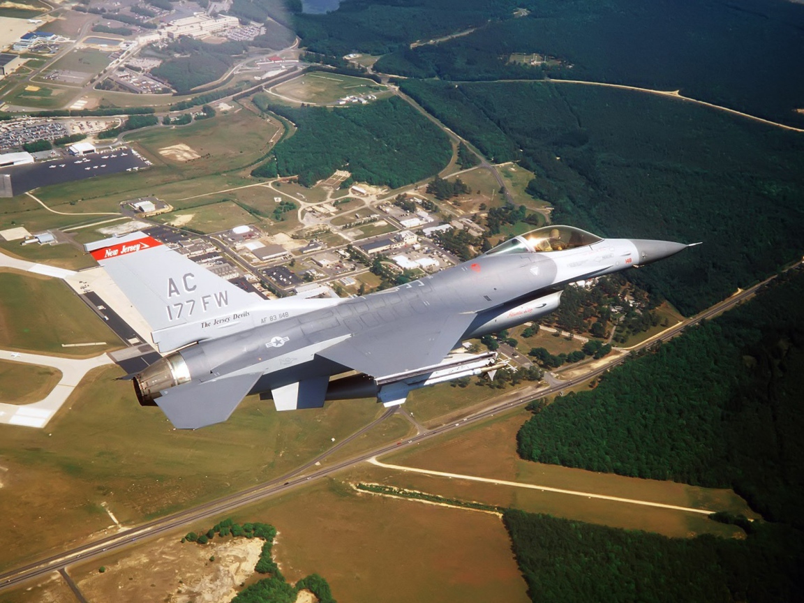 Истребитель F-16 выполняет маневр над землей