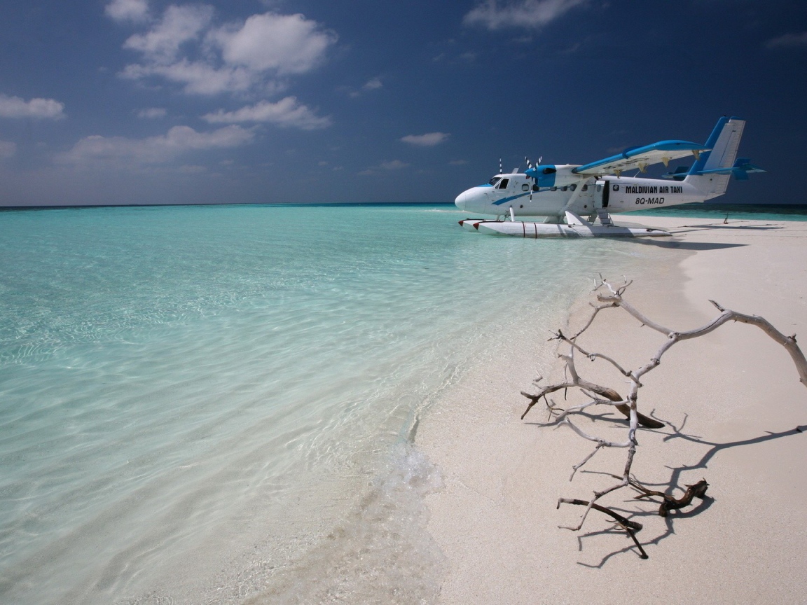 Самолет сел на воду у белого пляжа