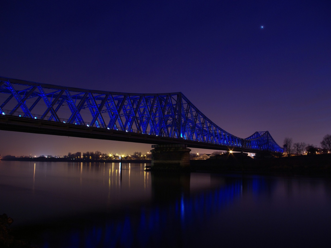 Синяя ночная подсветка моста через реку