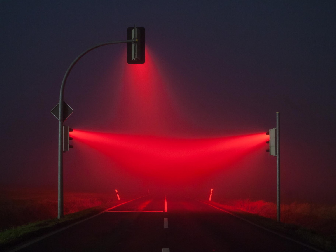 Красные светофоры освещают туман