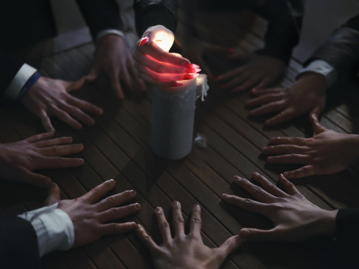 Люди вызывают духа при помощи свечи