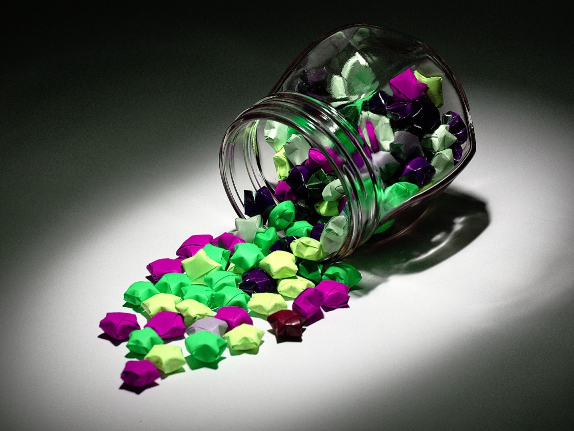 Конфеты в разноцветных обертках высыпались из банки