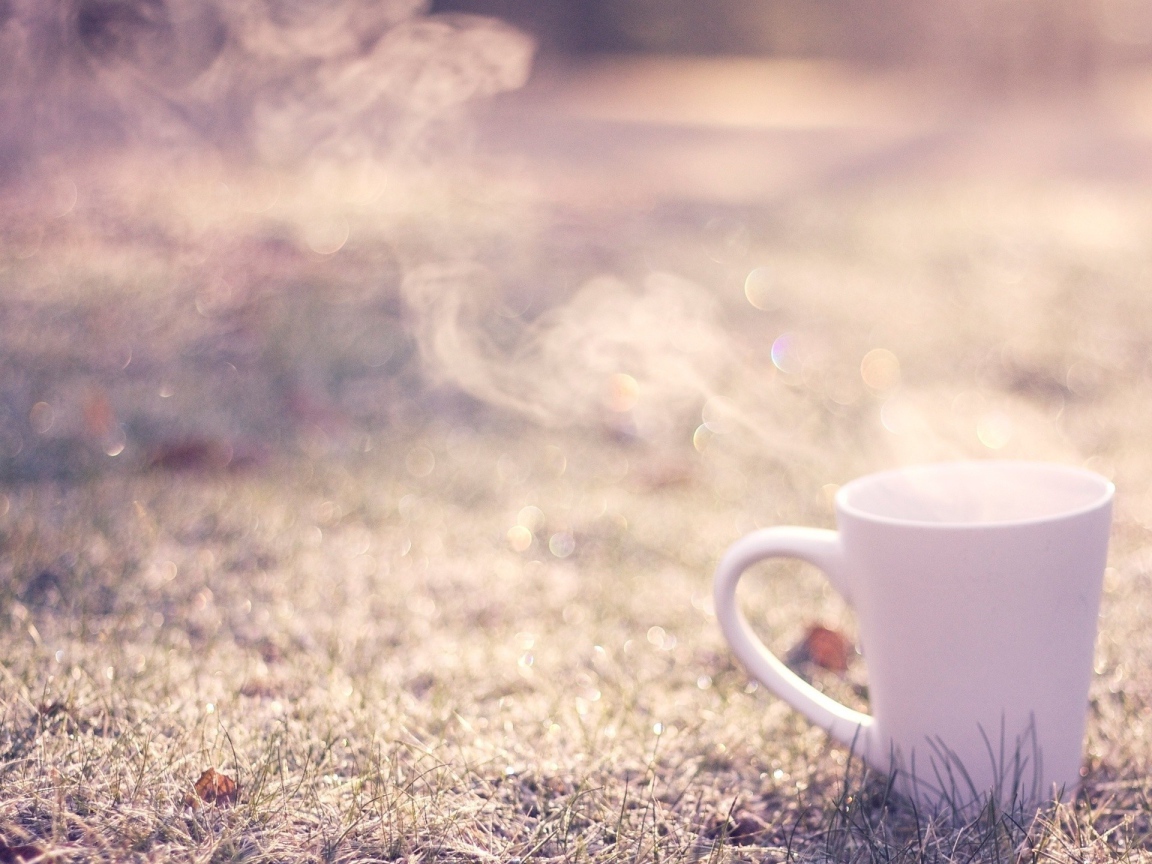 Дымящаяся чашка на траве