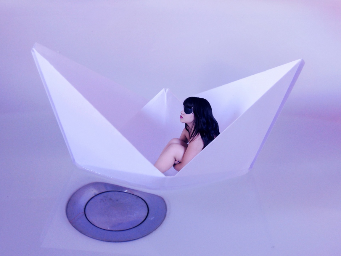 Девушка сидит в бумажном кораблике